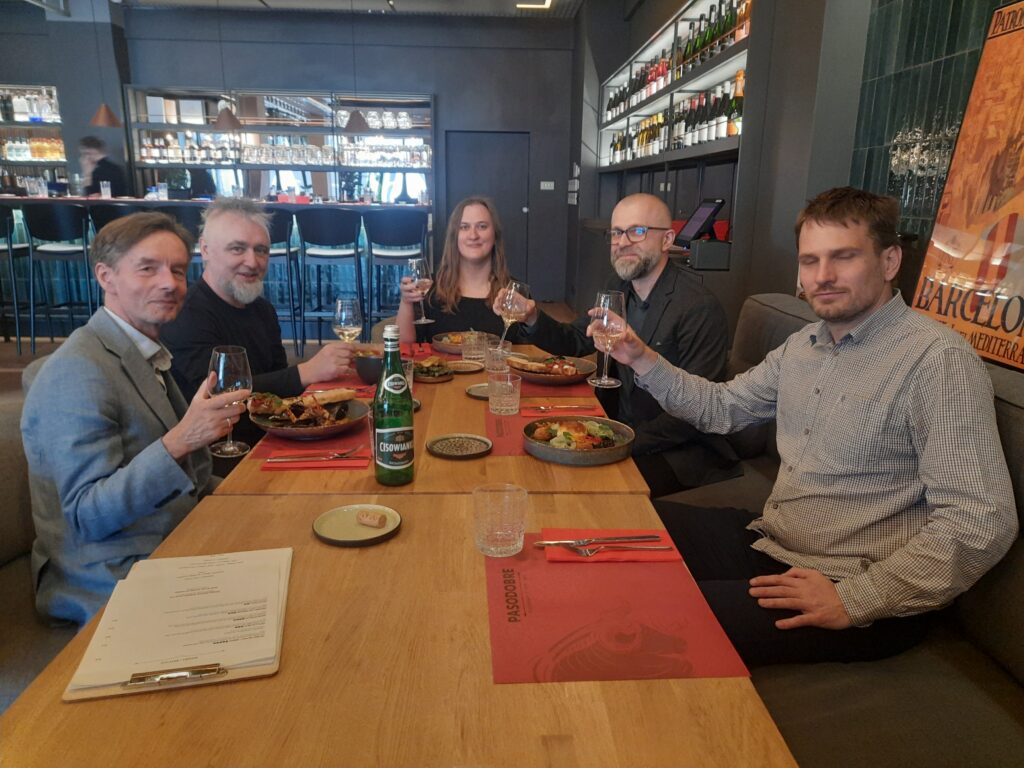 A group of people sitting in the restaurant having lunch and holding wine glasses