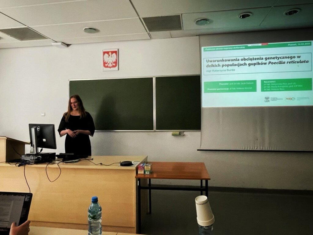 A women stadning in front of a desk and staring her presentation.
